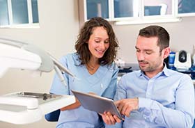 Dentist and patient discussing the cost of dental emergencies in Buzzards Bay