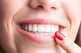 Closeup of person pointing to healthy smile