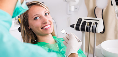 Happy dental team members interacting with patient