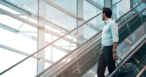Man dressed in business clothes, on escalator in airport